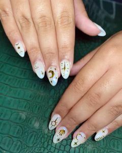 Nail Services at Lavish Scranton - A manicure with while nail polish and nail art with moon and stars.